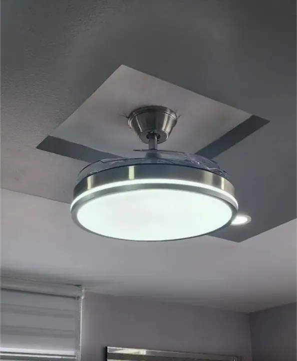 Ventilador de techo instalado en un techo bajo con luz blanca